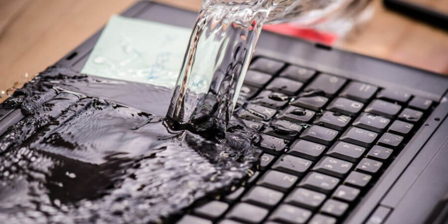 water spilling on laptop